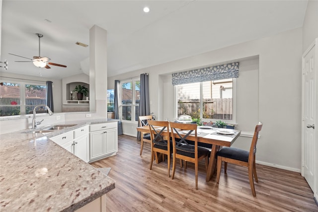 kitchen with sink, light hardwood / wood-style flooring, ceiling fan, light stone counters, and white cabinetry