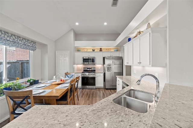 kitchen featuring light stone countertops, white cabinetry, sink, a healthy amount of sunlight, and stainless steel appliances