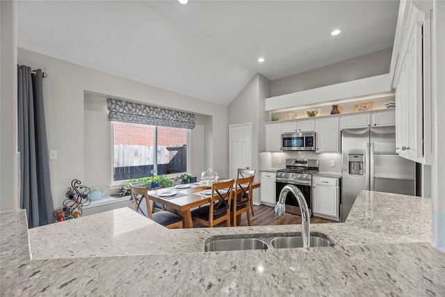 kitchen featuring white cabinets, light stone counters, sink, and appliances with stainless steel finishes