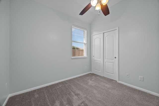 unfurnished bedroom with ceiling fan, a closet, carpet floors, and vaulted ceiling