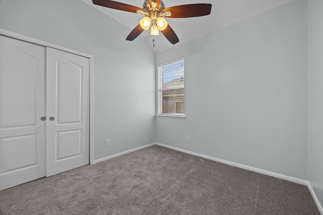 unfurnished bedroom featuring ceiling fan, a closet, light carpet, and vaulted ceiling