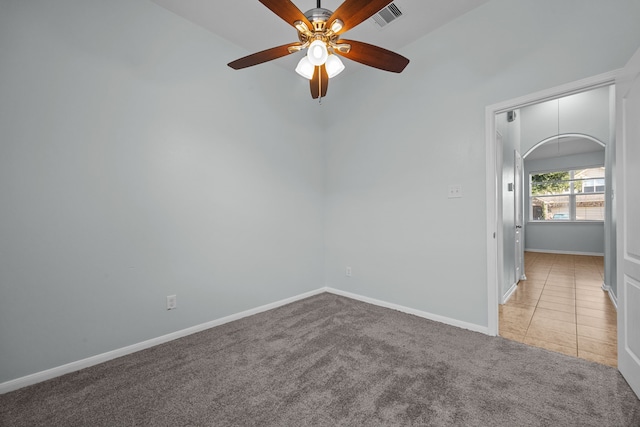 unfurnished room featuring ceiling fan, light colored carpet, and vaulted ceiling