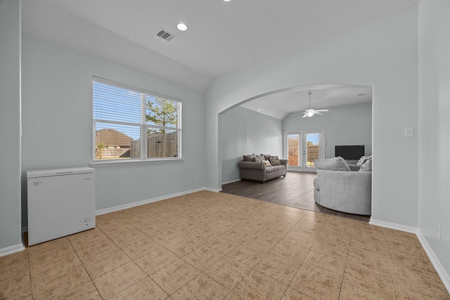 living room with ceiling fan, light tile patterned flooring, lofted ceiling, and french doors