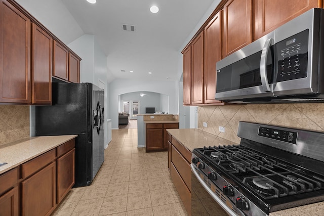 kitchen with light tile patterned floors, backsplash, and stainless steel appliances