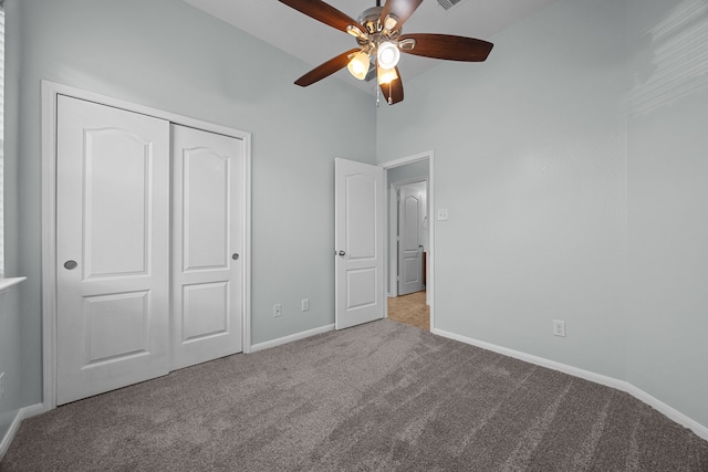 unfurnished bedroom featuring ceiling fan, a closet, high vaulted ceiling, and light colored carpet