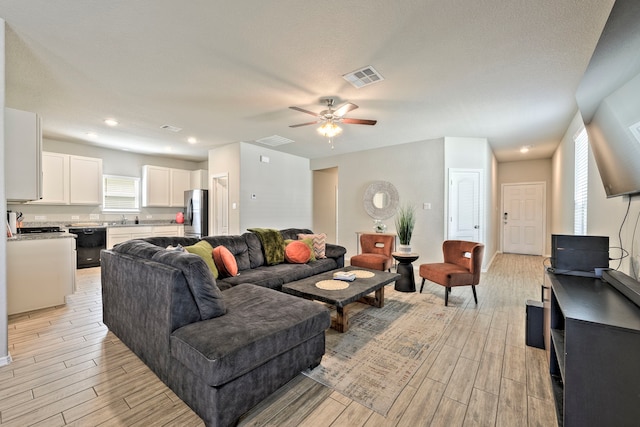 living room with ceiling fan and sink