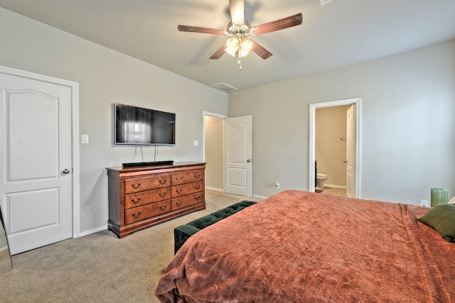 carpeted bedroom with ensuite bathroom and ceiling fan