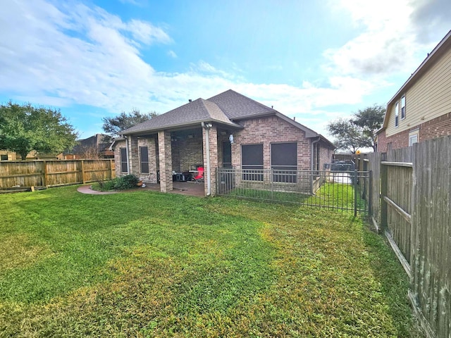 rear view of house with a lawn and a patio area