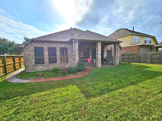 rear view of house featuring a patio area and a yard