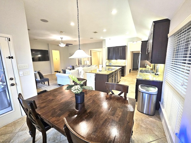 tiled dining room featuring ceiling fan and sink