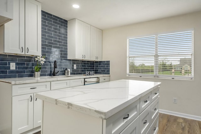 kitchen with white cabinets, backsplash, and sink