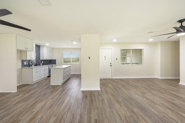 kitchen featuring a kitchen island, ceiling fan, dishwasher, hardwood / wood-style floors, and white cabinetry