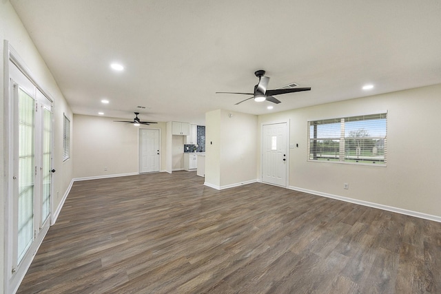 unfurnished living room featuring ceiling fan and dark hardwood / wood-style flooring