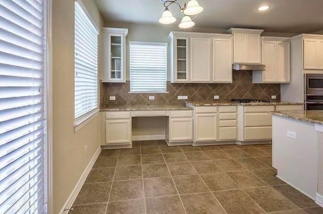 kitchen featuring pendant lighting, white cabinets, appliances with stainless steel finishes, and dark tile patterned flooring