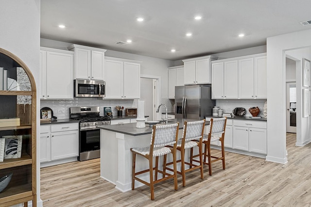 kitchen featuring white cabinetry, a breakfast bar area, and appliances with stainless steel finishes