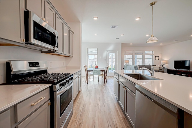 kitchen featuring plenty of natural light, gray cabinets, sink, and stainless steel appliances