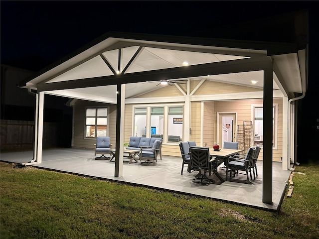 patio at twilight with an outdoor living space and a yard