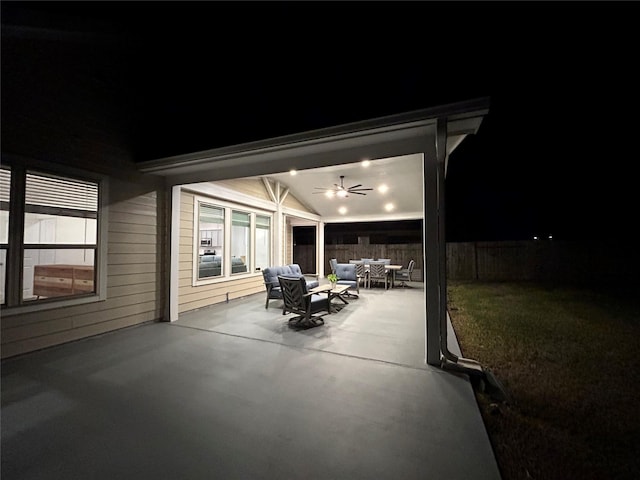 patio at twilight with ceiling fan and an outdoor hangout area