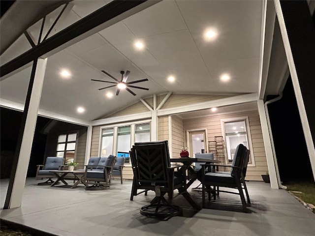 dining area with wood walls, ceiling fan, and lofted ceiling