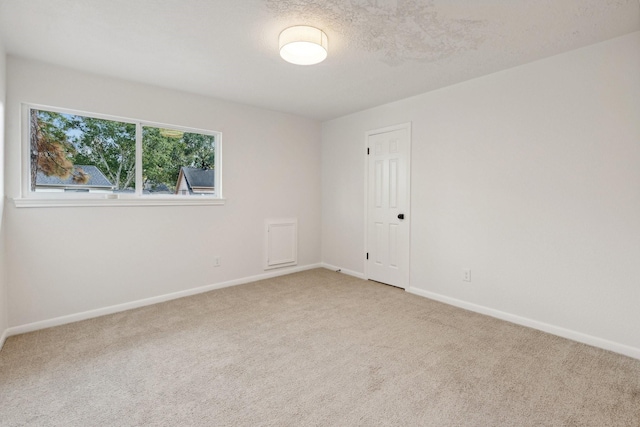 carpeted empty room featuring a textured ceiling