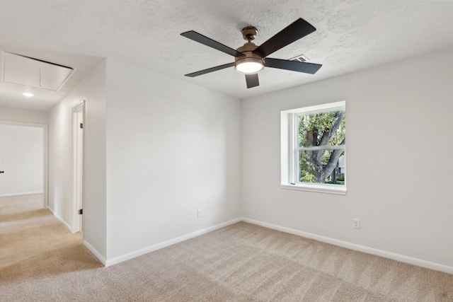 carpeted spare room with a textured ceiling and ceiling fan