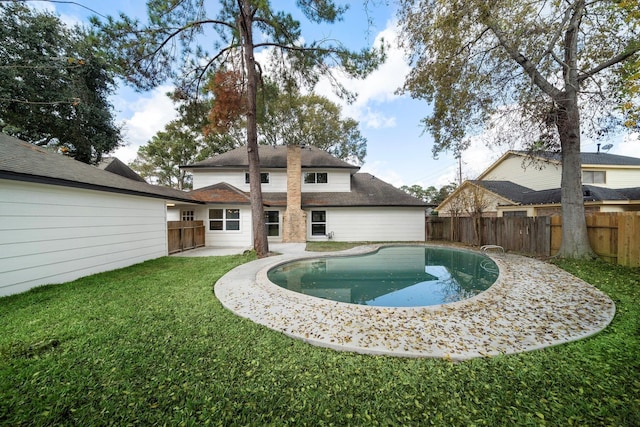 rear view of property with a patio area, a fenced in pool, and a yard