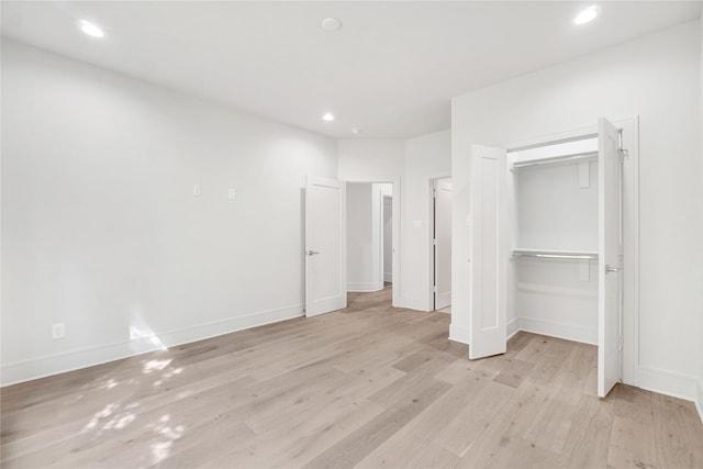 unfurnished bedroom featuring light wood-type flooring and a closet