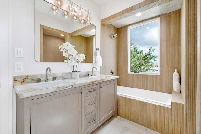 bathroom with vanity and tiled bath