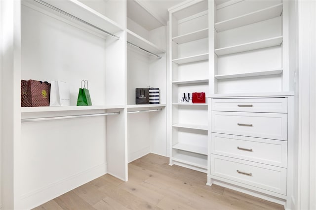 walk in closet with light hardwood / wood-style flooring