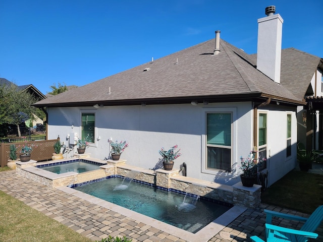 rear view of house featuring an in ground hot tub and pool water feature