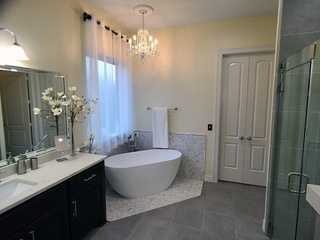 bathroom with tile patterned floors, vanity, shower with separate bathtub, and an inviting chandelier