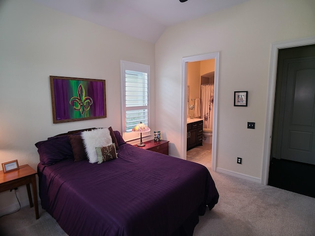 carpeted bedroom featuring ensuite bathroom and vaulted ceiling