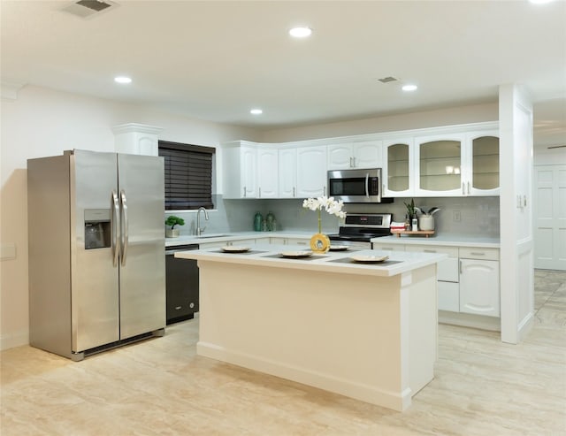 kitchen featuring white cabinetry, tasteful backsplash, a center island, and appliances with stainless steel finishes