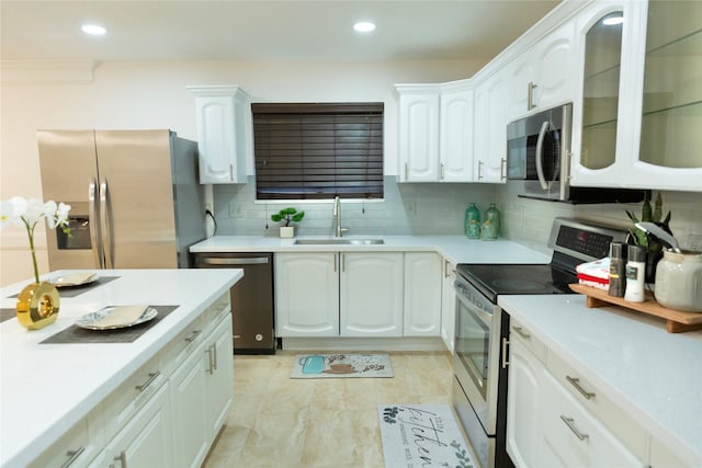 kitchen featuring white cabinets, stainless steel appliances, sink, and decorative backsplash