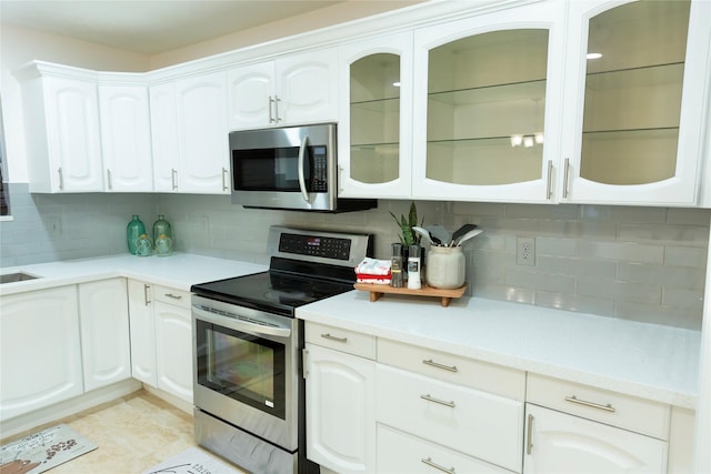 kitchen with white cabinets, appliances with stainless steel finishes, backsplash, and sink