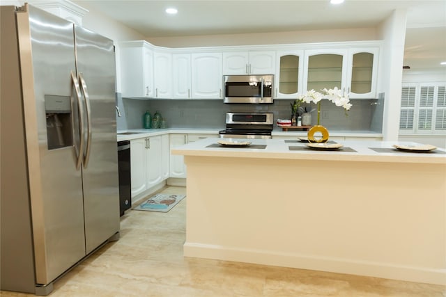 kitchen with appliances with stainless steel finishes, white cabinets, sink, and decorative backsplash