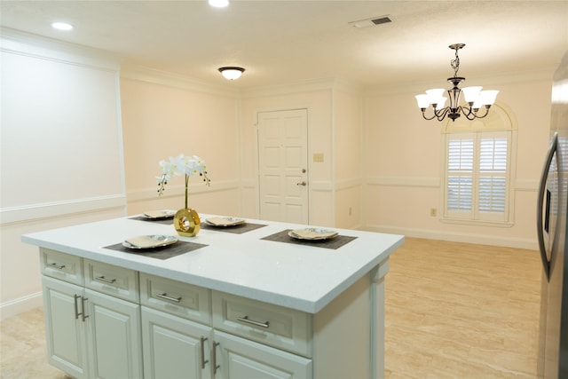 kitchen featuring a kitchen island, an inviting chandelier, crown molding, and hanging light fixtures