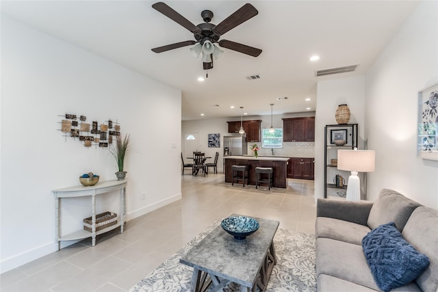 living room featuring light tile patterned floors and ceiling fan