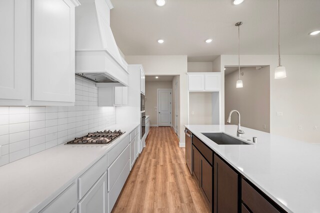 9760 Rockwell Dr, Willis, TX 77318 - kitchen with appliances with stainless steel finishes, custom range hood, light countertops, light wood finished floors, and recessed lighting