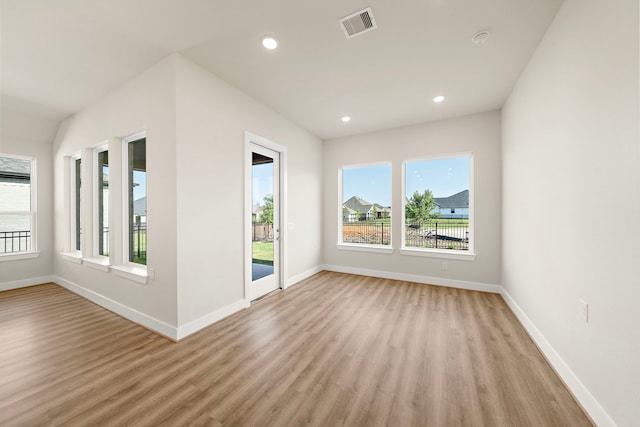 9760 Rockwell Dr, Willis, TX 77318 - empty room featuring healthy amount of natural light, light wood-type flooring, recessed lighting, and a smoke detector