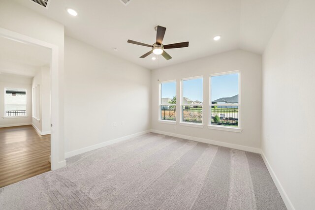 9760 Rockwell Dr, Willis, TX 77318 - empty room featuring light colored carpet, plenty of natural light, ceiling fan, vaulted ceiling, and recessed lighting