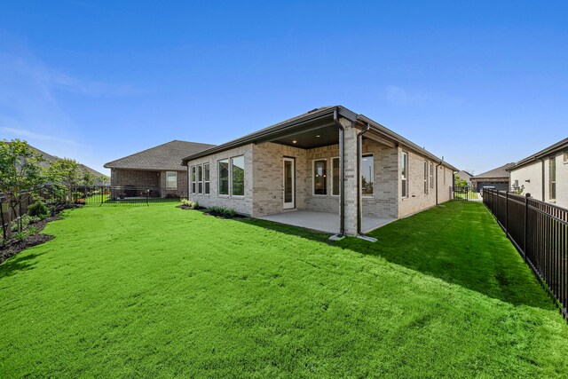 9760 Rockwell Dr, Willis, TX 77318 - back of property with brick siding, a fenced backyard, and a patio