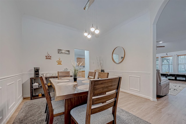 dining space featuring light wood-type flooring and crown molding