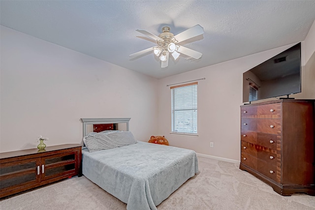 carpeted bedroom featuring a textured ceiling and ceiling fan