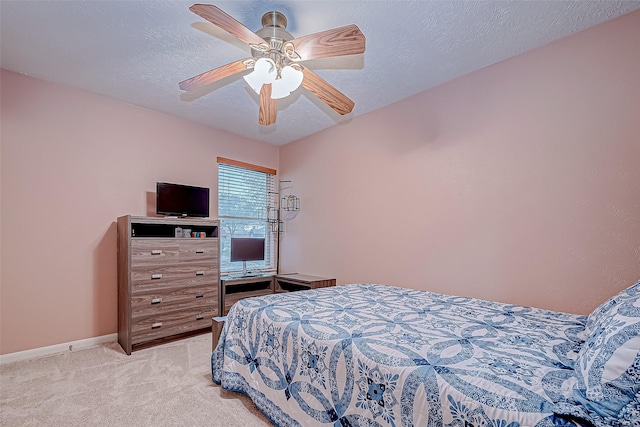 bedroom with ceiling fan, light carpet, and a textured ceiling