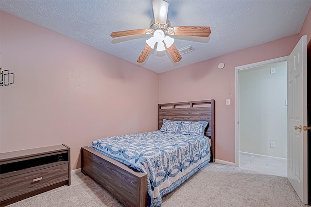 carpeted bedroom featuring ceiling fan and a textured ceiling