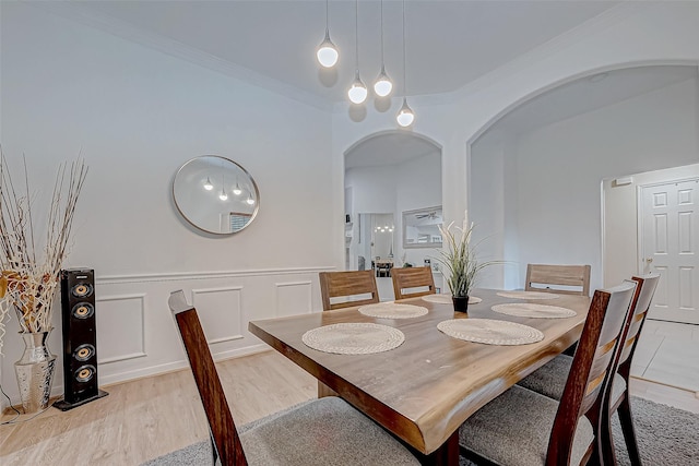 dining room with light wood-type flooring and crown molding