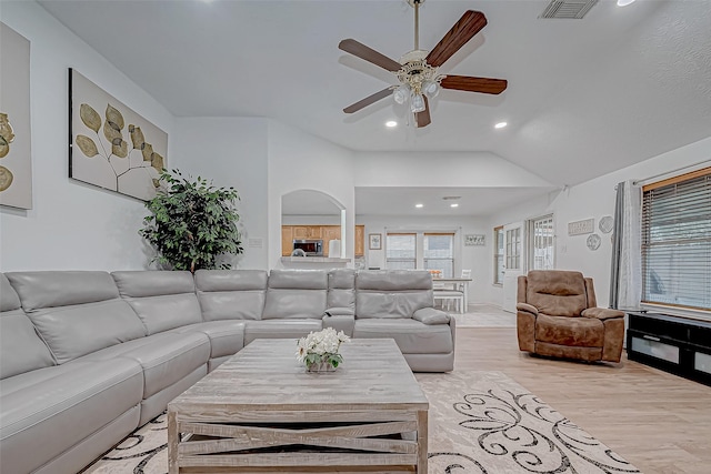 living room with ceiling fan, light hardwood / wood-style floors, and lofted ceiling