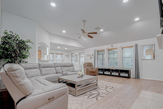 living room with high vaulted ceiling, light hardwood / wood-style flooring, ceiling fan, and plenty of natural light