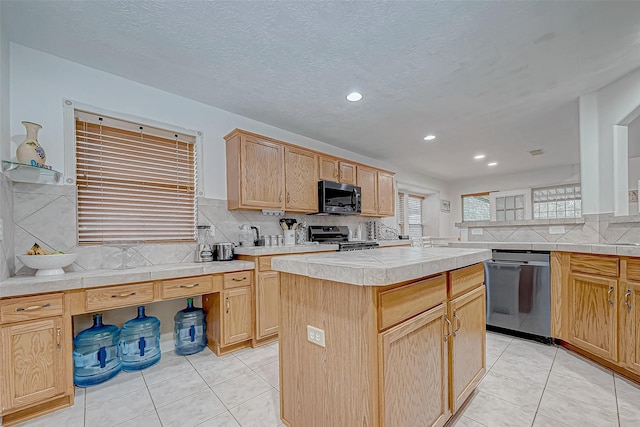 kitchen with decorative backsplash, a center island, light tile patterned floors, and appliances with stainless steel finishes